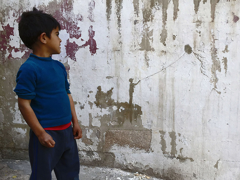 pejac peels paint off palestinian walls to compose evocative landscapes