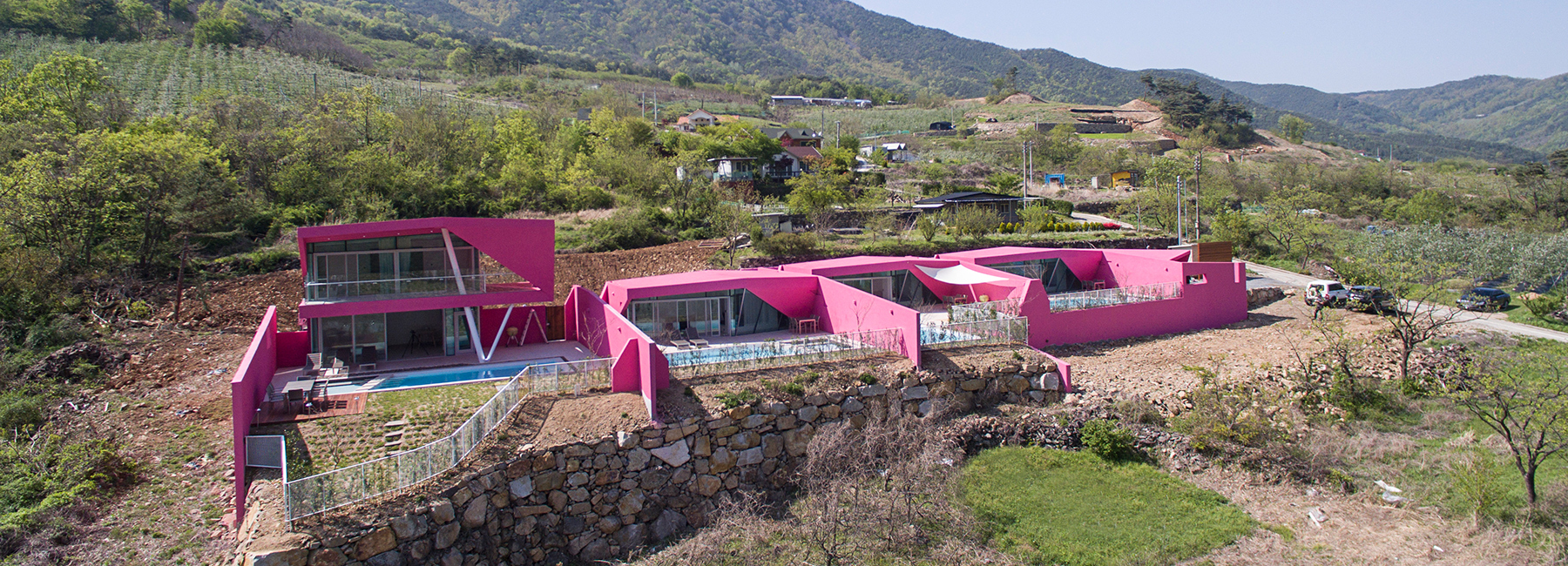 moon hoon creates four vibrant pink villas that overlook the korean countryside