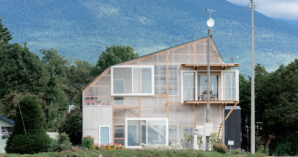 deformed roof house in rural japan receives greenhouse-like extension