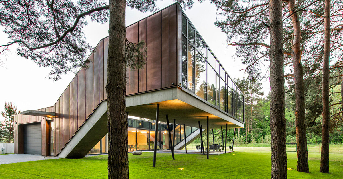copper-clad zigzag house by g.natkevicius & partners hovers above pine forest in lithuania