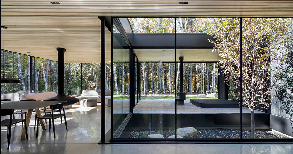 in quebec forests, a glass house surrounds an apple tree courtyard