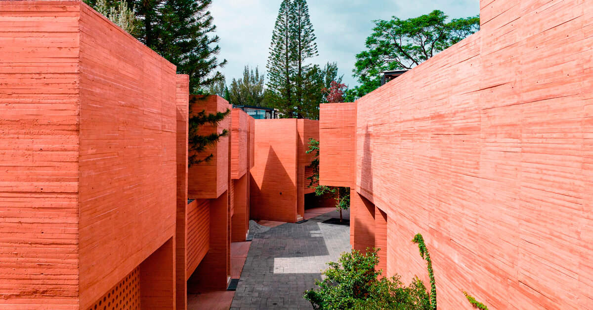Bloques de hormigón naranja bordean un complejo residencial en México