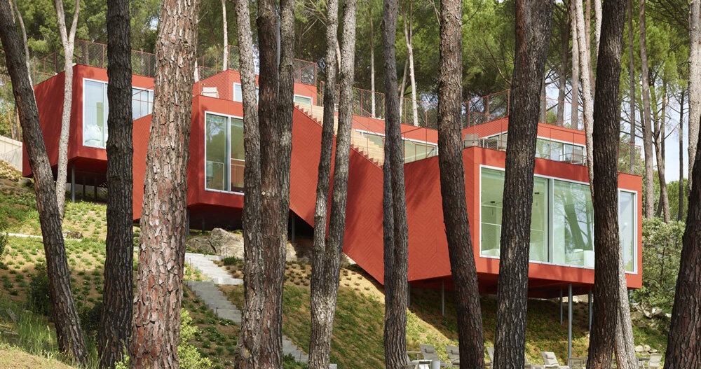 Casa Roja de Estudio Entrecitio teje en una ladera de madera en España