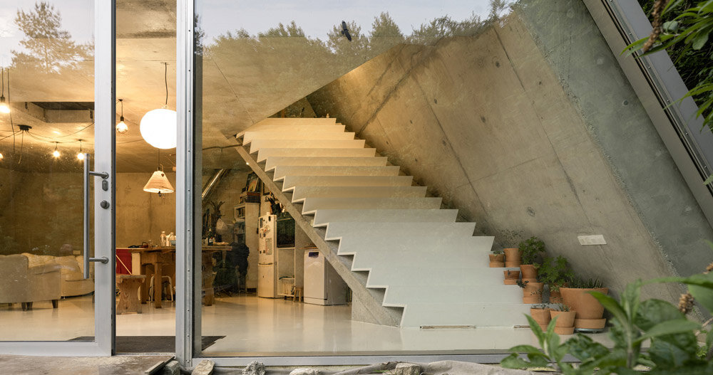 studeny architekti embeds concrete shell house into a hillside in pernek, slovakia