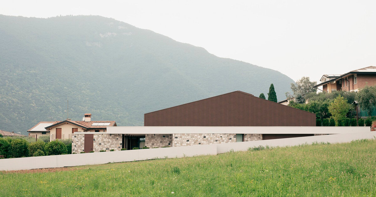 Pareti in pietra ed elementi in legno adornano la residenza nel nord Italia