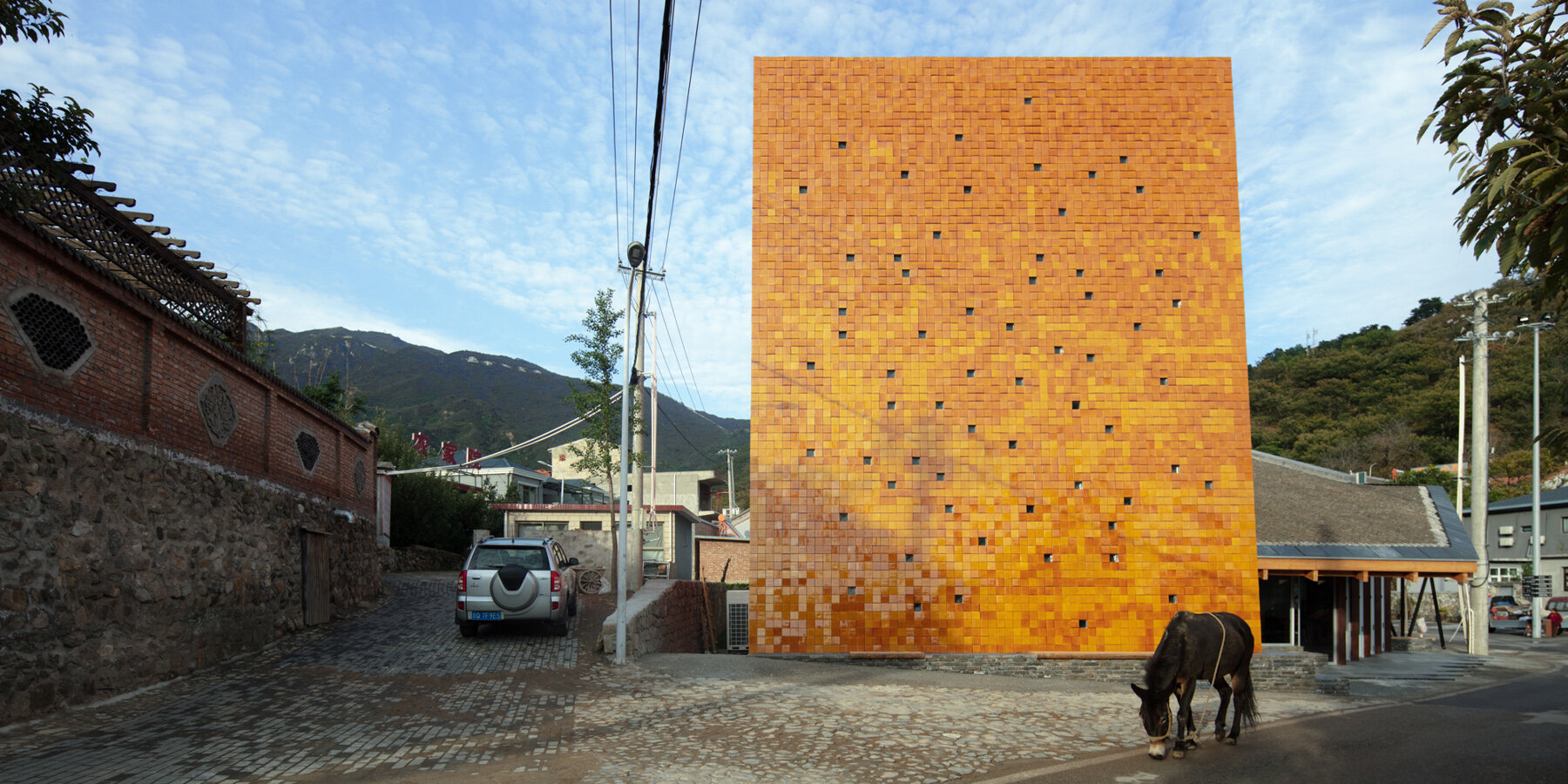 WAAAM museum’s glazed yellow facade enlivens the beigou village in china