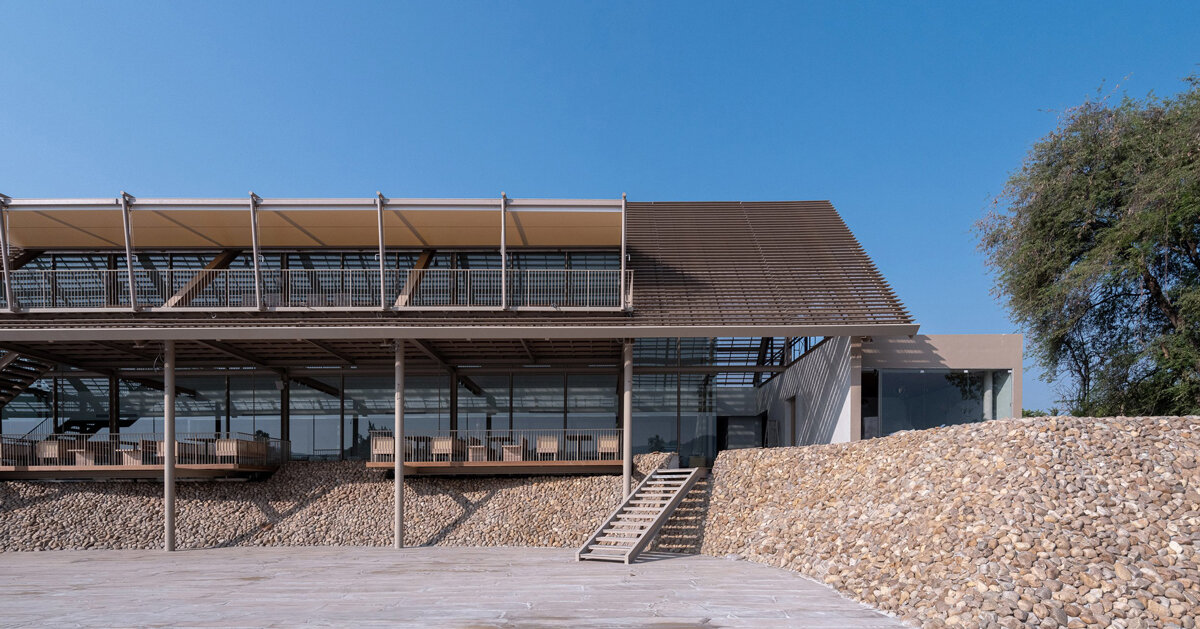 honey-colored gravel walls delineate PHTAA’s restaurant by river kwai in thailand