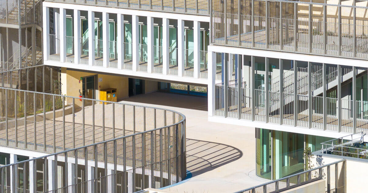 interlocking stone volumes sculpt layered school complex by brenac & gonzalez & associés