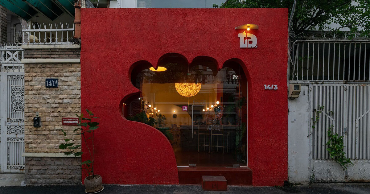cafe's red facade carves welcoming hand-shaped entrance in vietnam