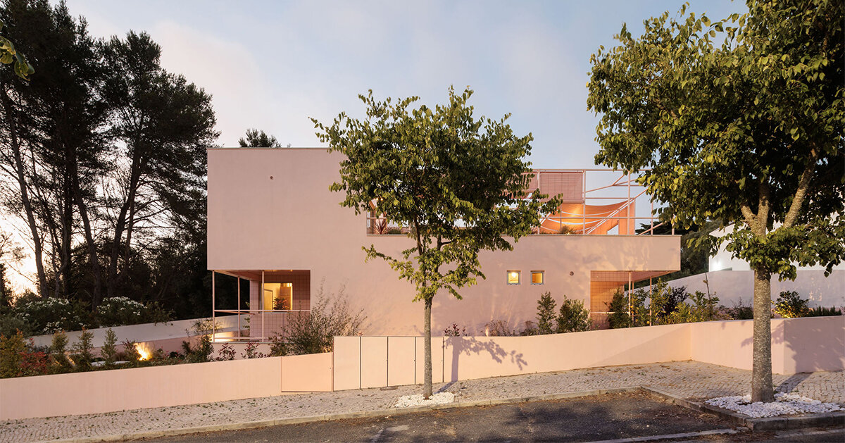 atelier RUA’s light pink house contrasts with surrounding greenery in portugal