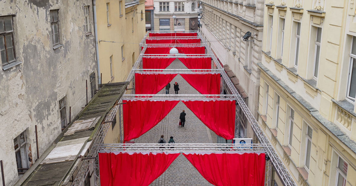 red and white curtains transform czech historic center's pathways into christmas installation