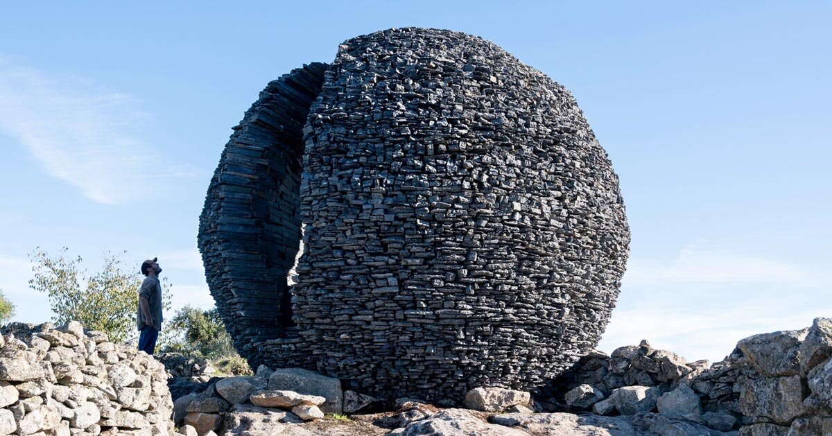 atelier yokyok sculpts sphere land installation out of black schist and granite in portugal