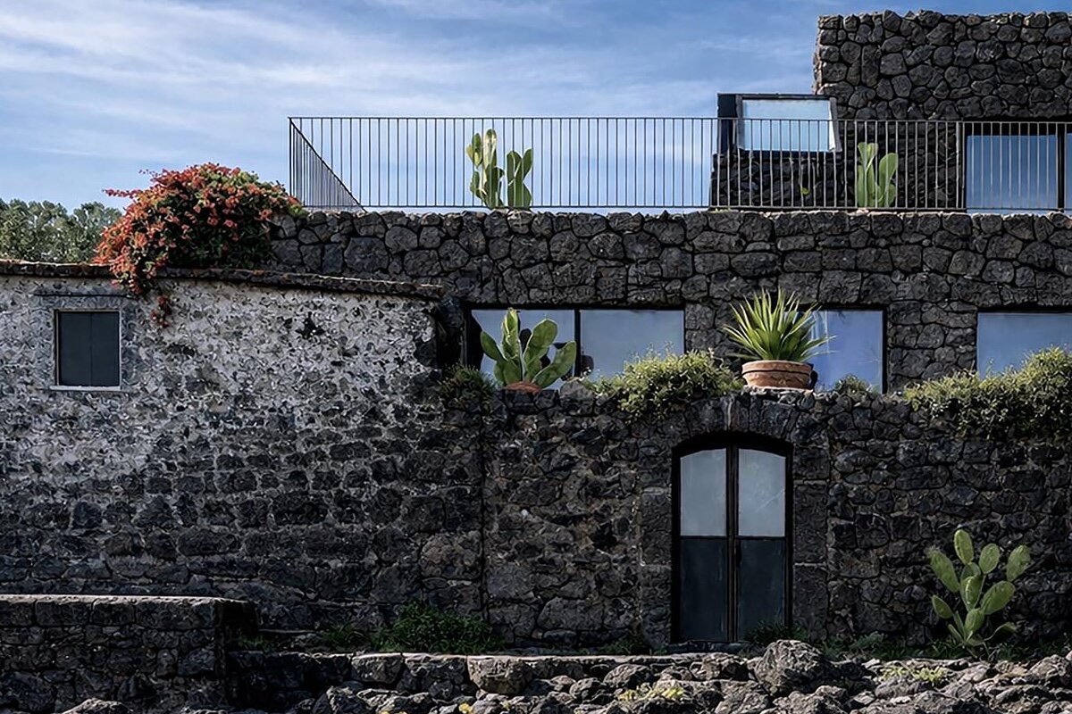 lava stone and old fisherman's house merge into contemporary villa on sicilian coast
