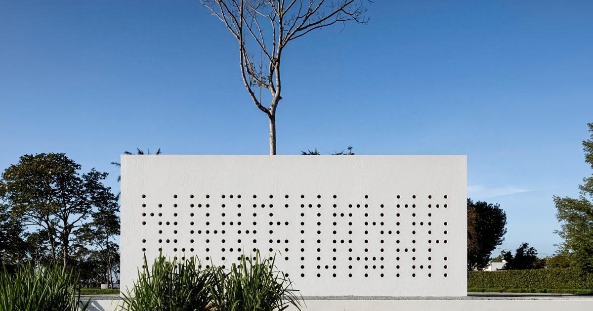 white perforated cubic facade wraps hybrid home and studio around a tree in brazil
