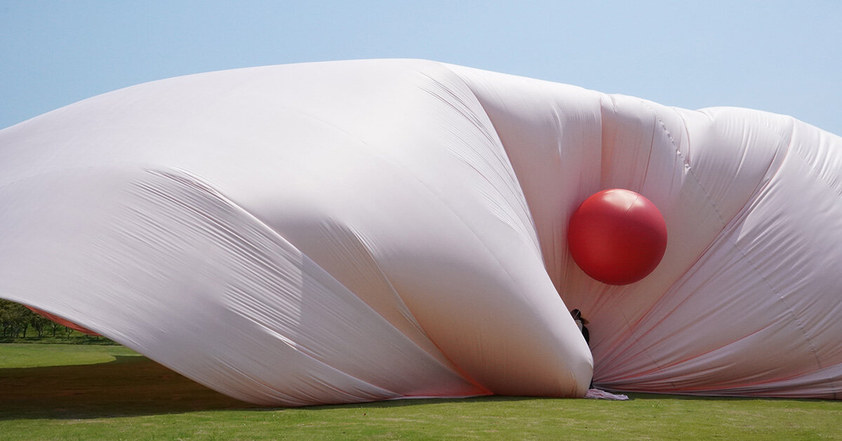 red balloons lift flowing fabric into a wedding playground by suki+partners in china