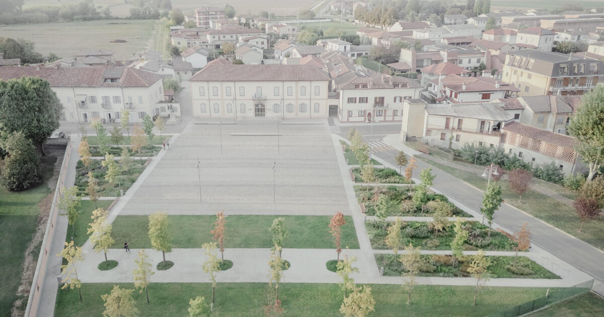 fifty oak trees and stone-paved clearing shape italian piazza by ghisellini architetti