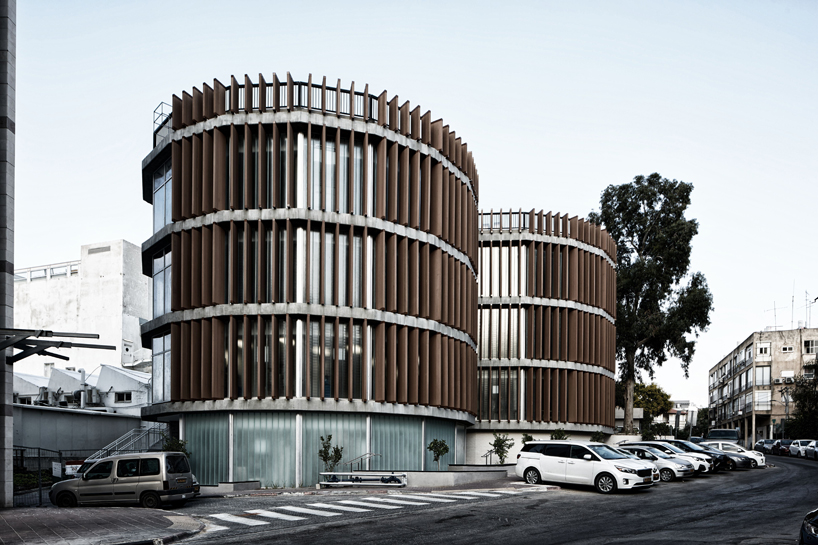 two translucent cylinders of wooden louvres extend the design college campus in ramat gan, by geotectura