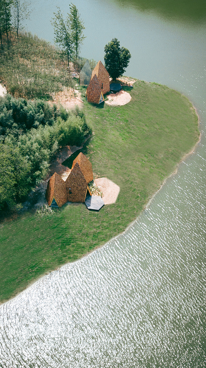 wooden shingles overlay cluster of monolithic cabins on chinese waterfront