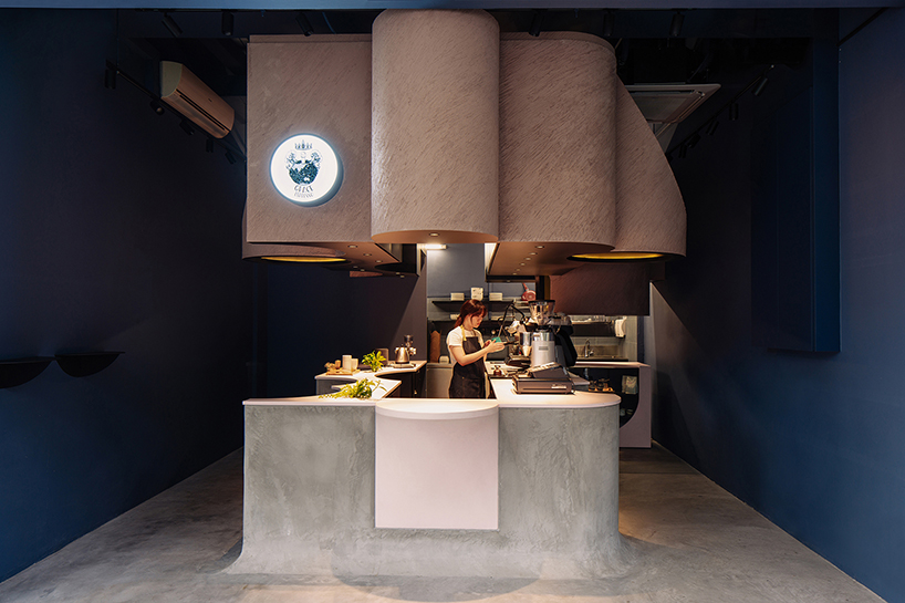 studio SKLIM's 'voids cafe' in singapore is carved out of a monolithic concrete block