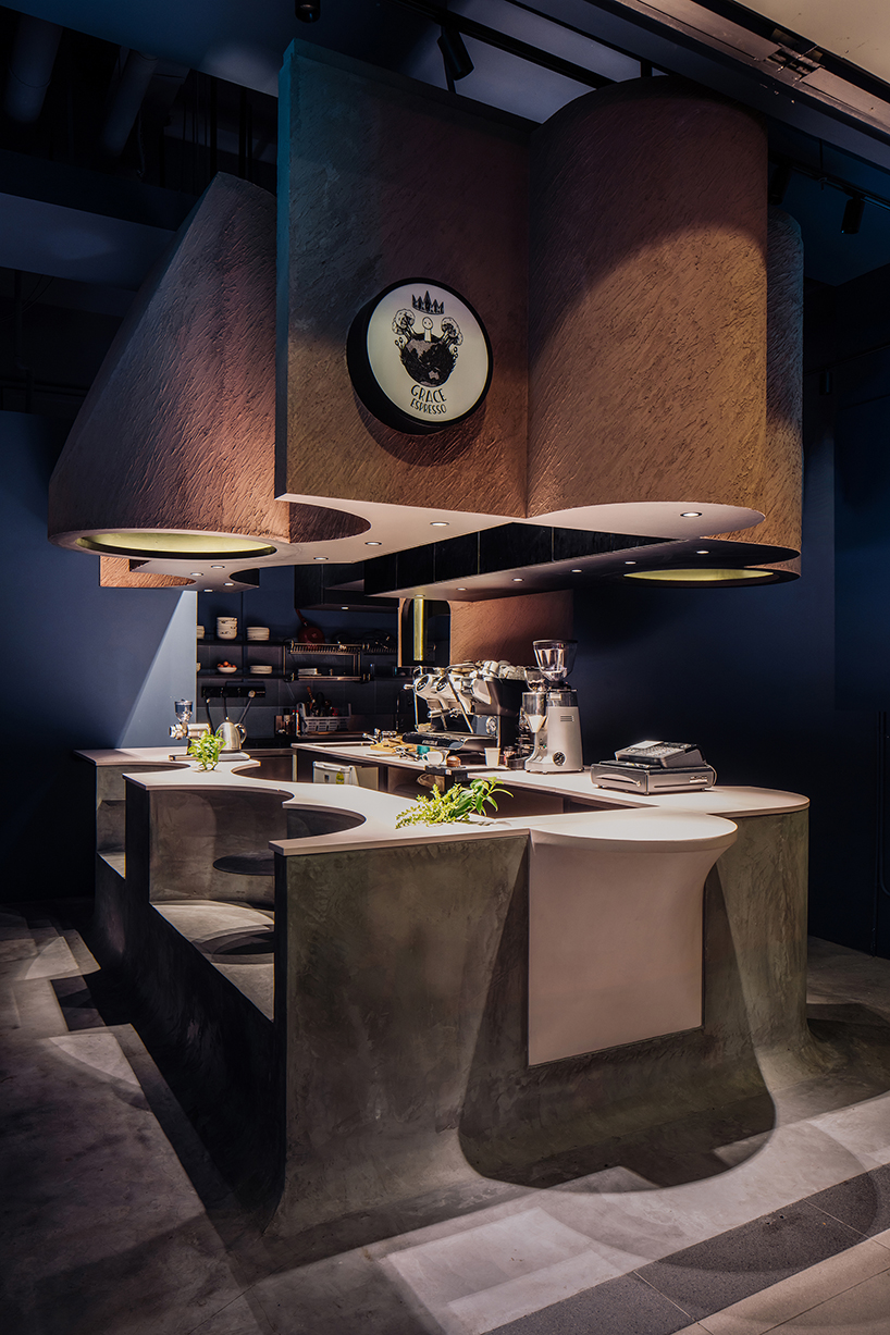 studio SKLIM 'voids cafe' in singapore is carved out of a monolithic concrete block