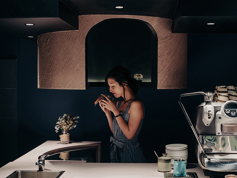 studio SKLIM's 'voids cafe' in singapore is carved out of a monolithic concrete block