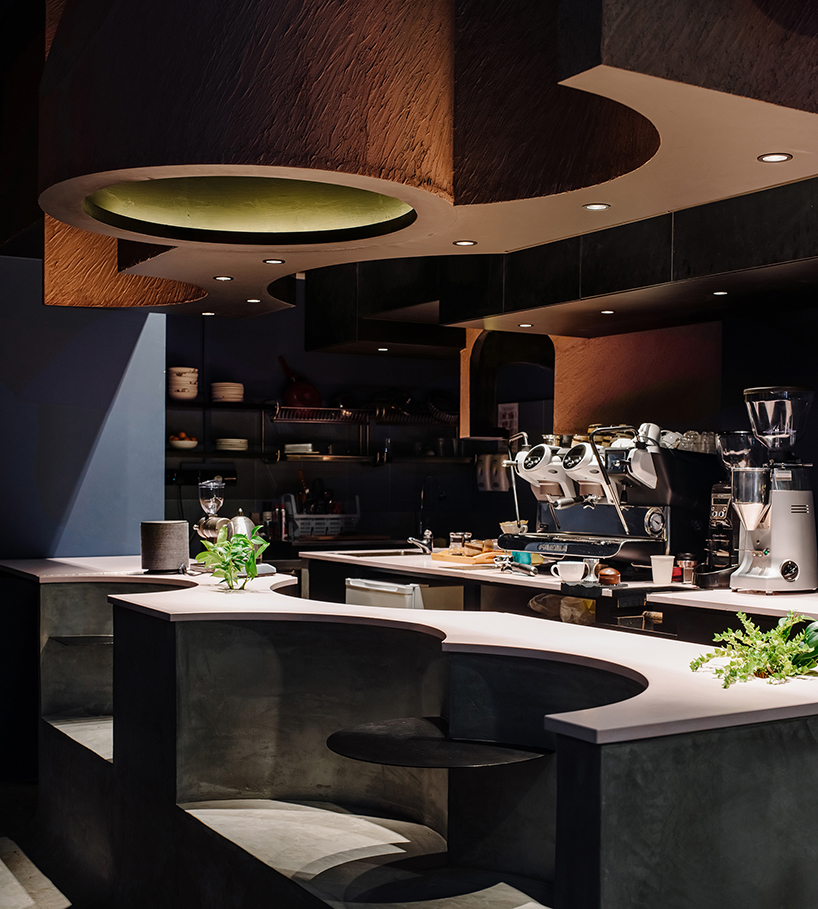 studio SKLIM's 'voids cafe' in singapore is carved out of a monolithic concrete block