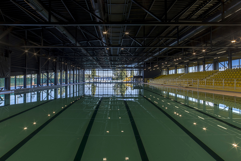 idis turato wraps yellow swimming complex interiors into black asymmetrical volume designboom
