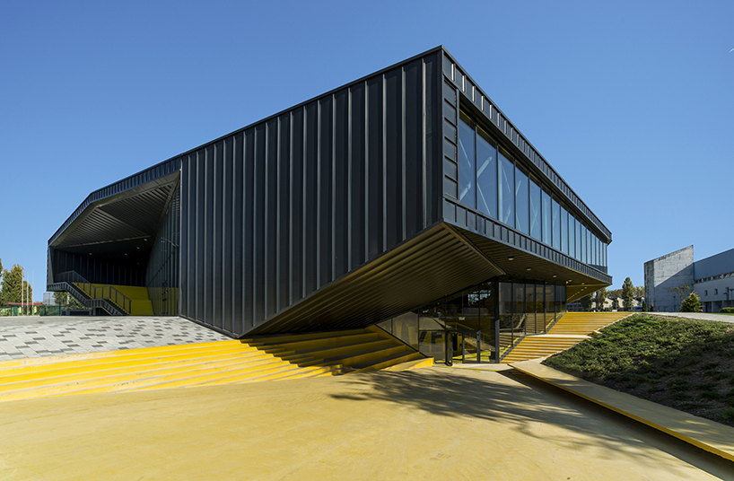 idis turato wraps yellow swimming complex interiors into black asymmetrical volume designboom