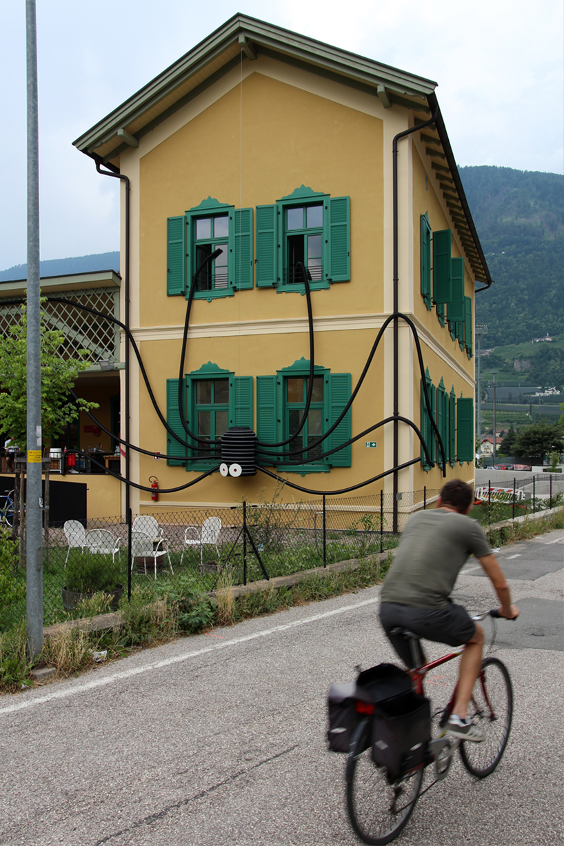 moradavaga's spider sprawls across facade in italy, reminiscent of an old-school string phone