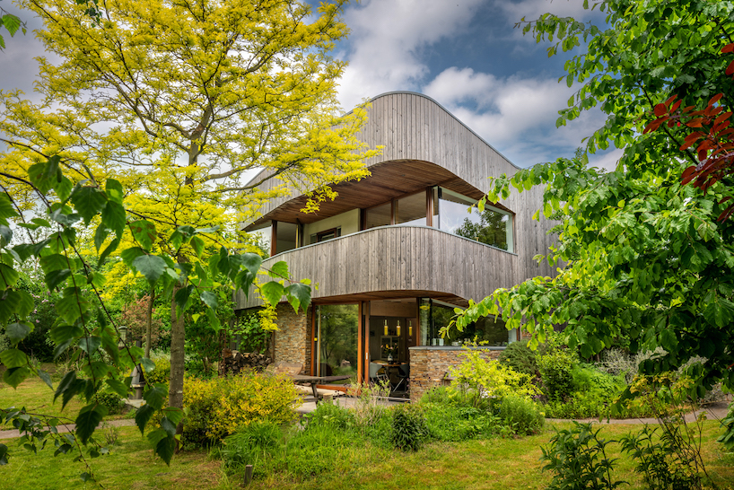 dynamic curved wooden volumes render camping villa's organic outline in amsterdam