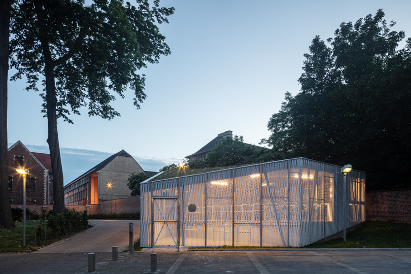 WAW architects builds permeable bicycle pavilion in belgium wrapped in a mesh metal box