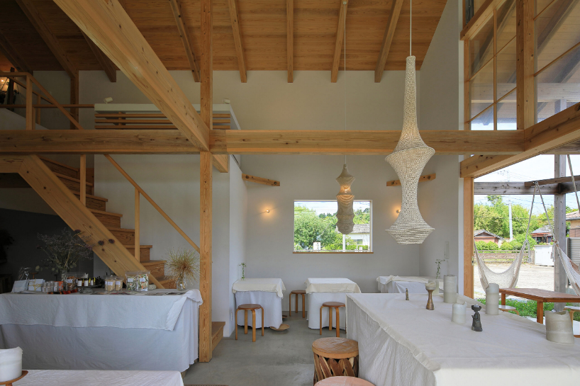 a forest of wooden pillars topped by a gently arched roof shape anandah café and residence - 6