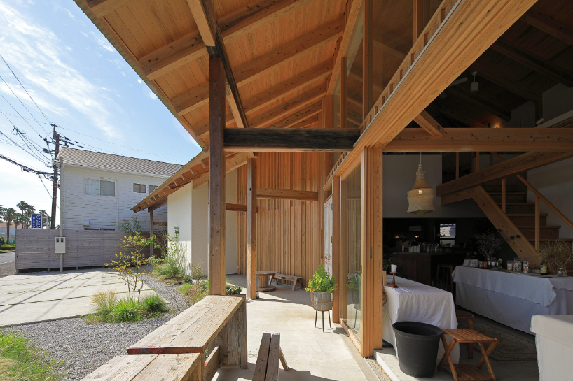 a forest of wooden pillars topped by a gently arched roof shape anandah café and residence - 4