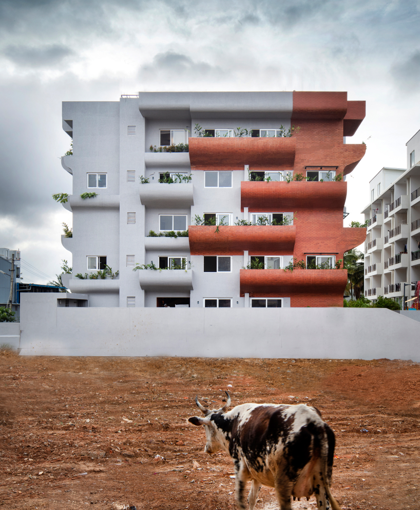 curving balconies double as environmental filters at purple ink studio's housing complex in bangalore