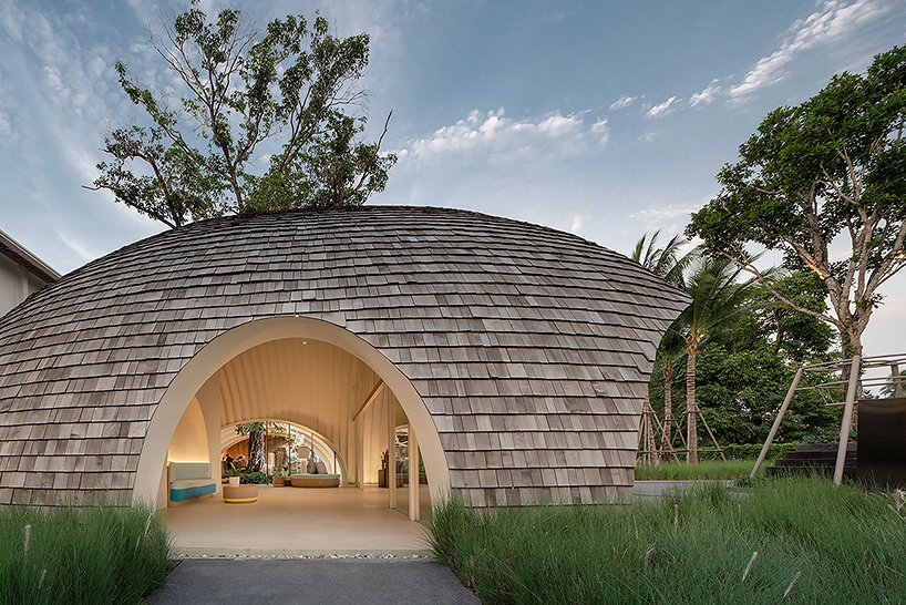 onion designs hotel's dome-shaped lobby clad in wooden shingles in thailand
