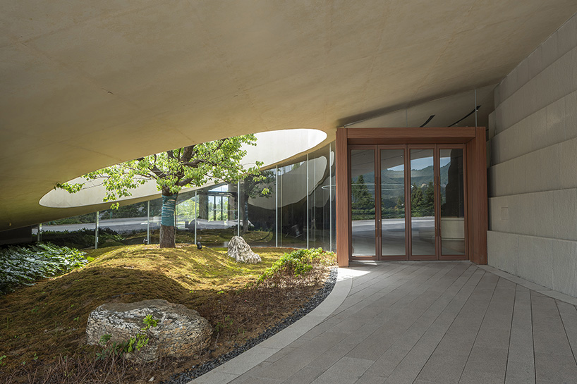 archstudio weaves resort exhibition center into the undulating landscape of dengcun, china