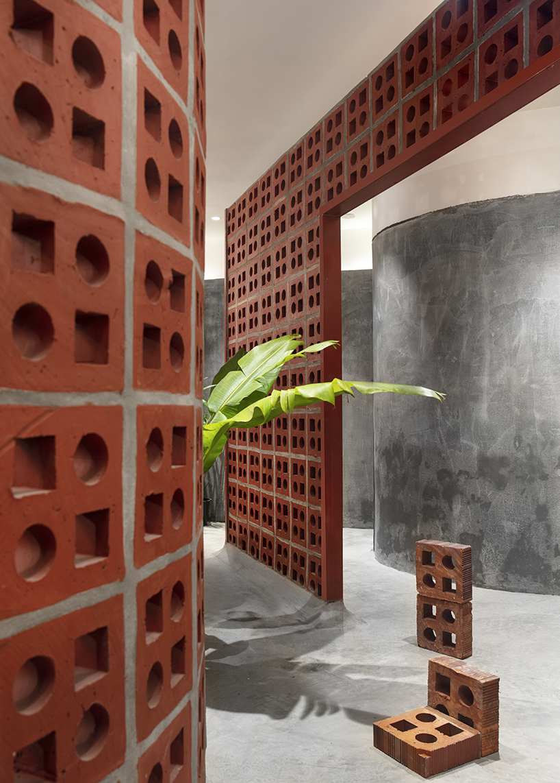 curving walls of red terracotta envelop RENESA’s 'terramater' gallery in india designboom