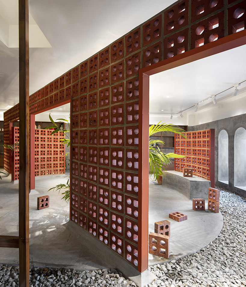 curving walls of red terracotta envelop RENESA’s 'terramater' gallery in india designboom
