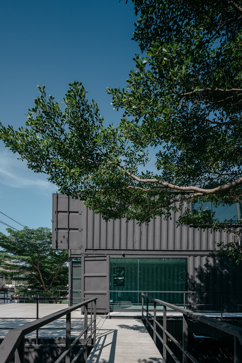 archimontage stacks shipping containers to form 'carcare' center in bangkok