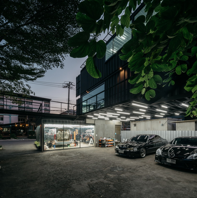 archimontage stacks shipping containers to form 'carcare' center in bangkok