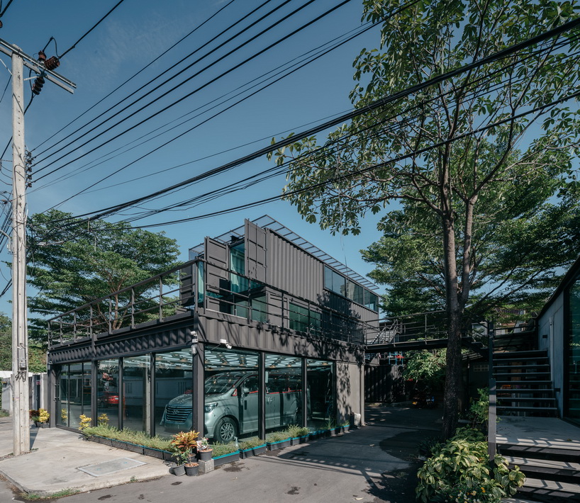 archimontage stacks shipping containers to form 'carcare' center in bangkok