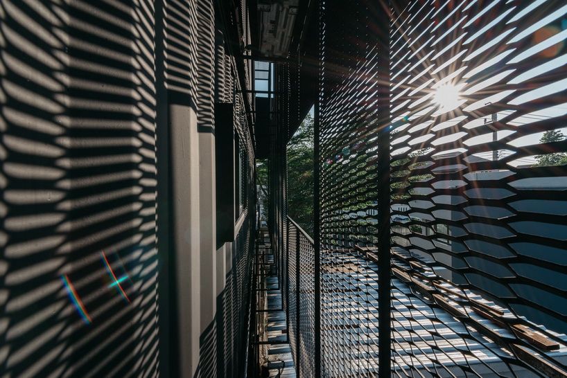 archimontage stacks shipping containers to form 'carcare' center in bangkok