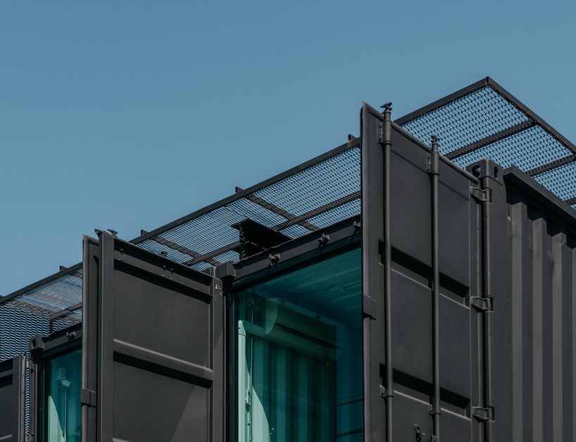 archimontage stacks shipping containers to form 'carcare' center in bangkok