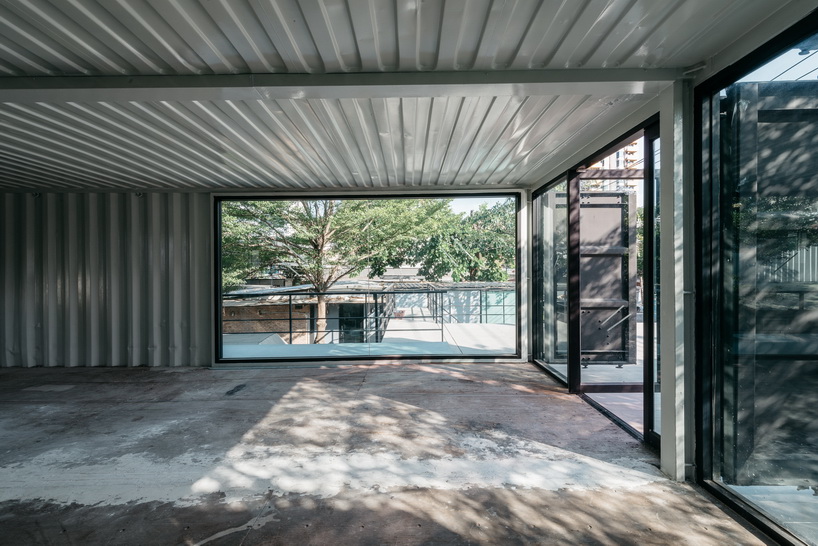 archimontage stacks shipping containers to form 'carcare' center in bangkok