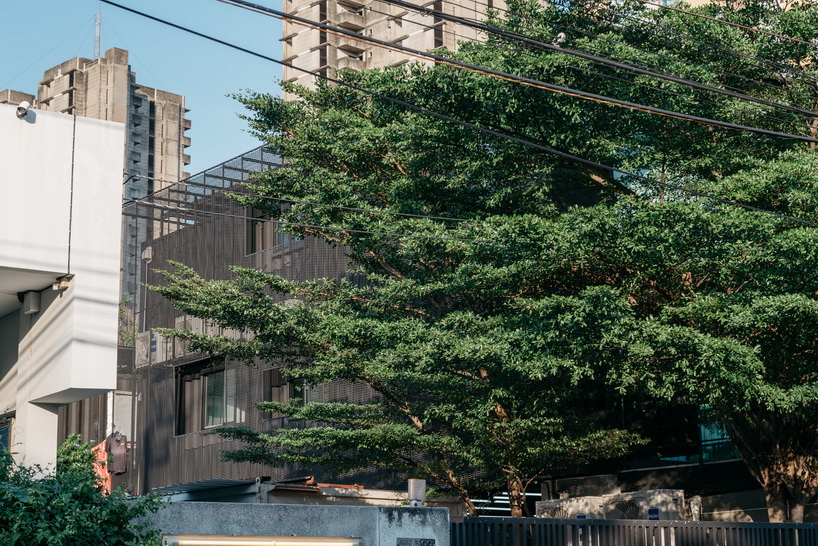 archimontage stacks shipping containers to form 'carcare' center in bangkok