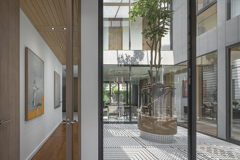 volumes, voids, and a warm ambience shape anonym studio's feng shui home in bangkok