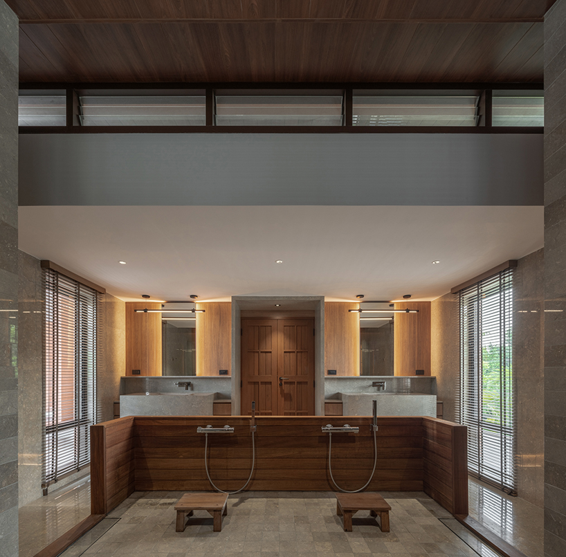 a pair of banyan trees anchors anonym studio’s open-air family house in thailand - 10