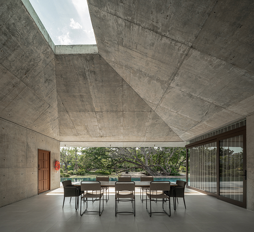 a pair of banyan trees anchors anonym studio’s open-air family house in thailand - 4