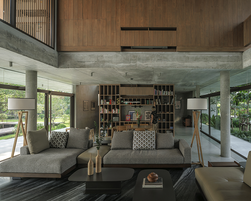 a pair of banyan trees anchors anonym studio’s open-air family house in thailand - 5