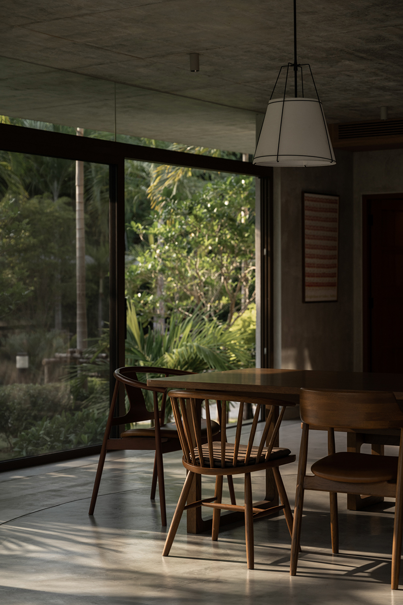 a pair of banyan trees anchors anonym studio’s open-air family house in thailand - 7